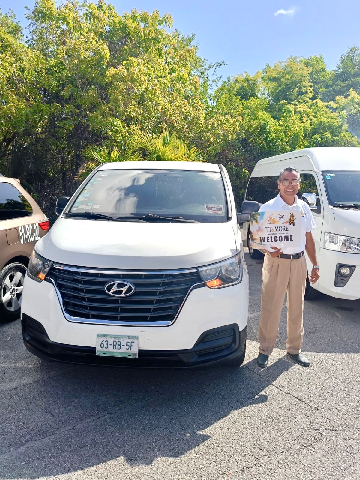 TT & More driver holding a welcome sign beside a private van
