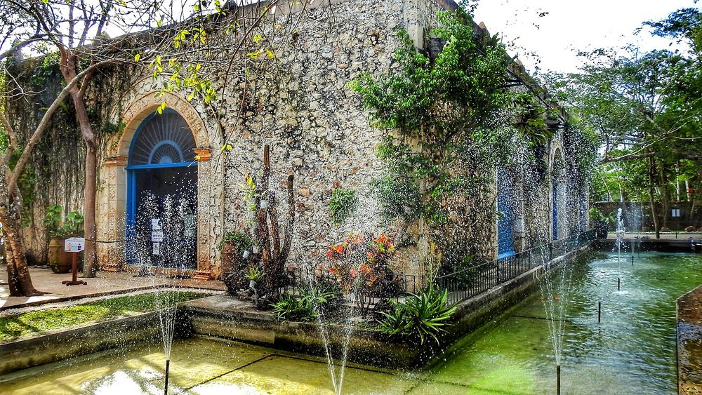 Edificio del restaurante y estanque con fuentes en la Hacienda Selva Maya